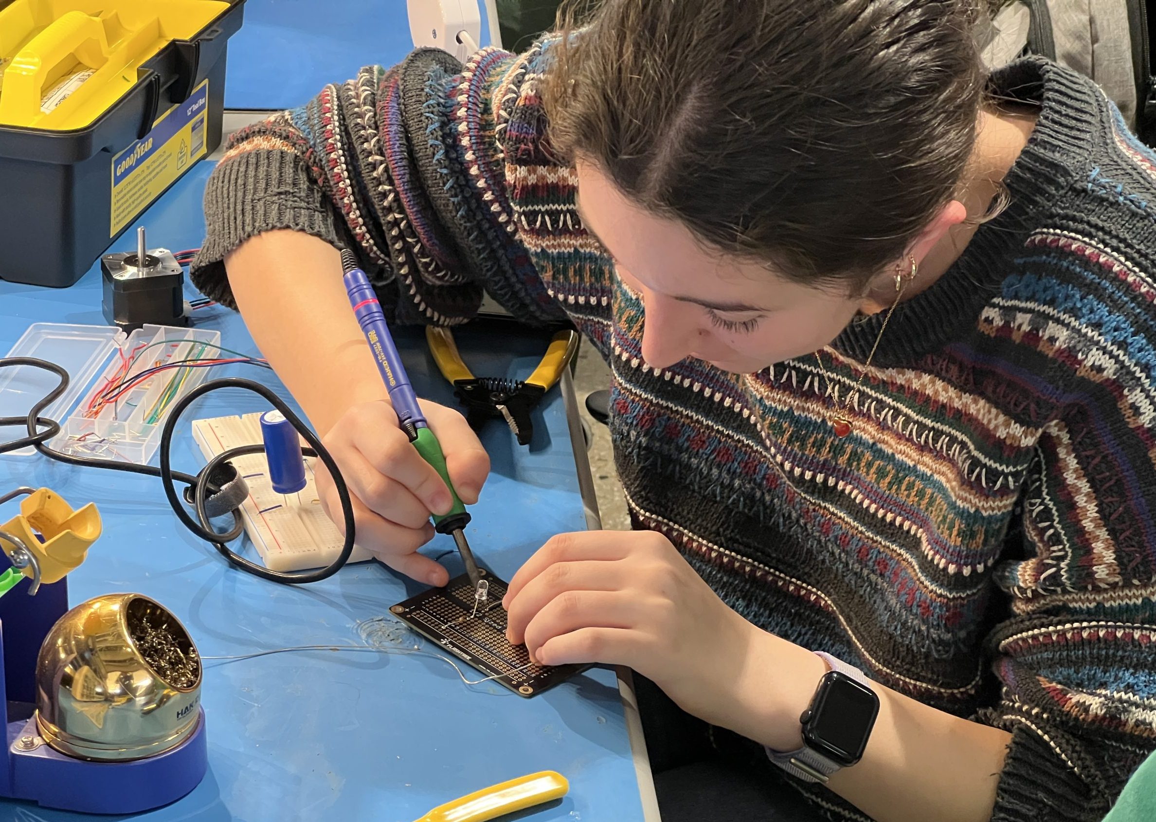 Student working with soldering iron in ECE210